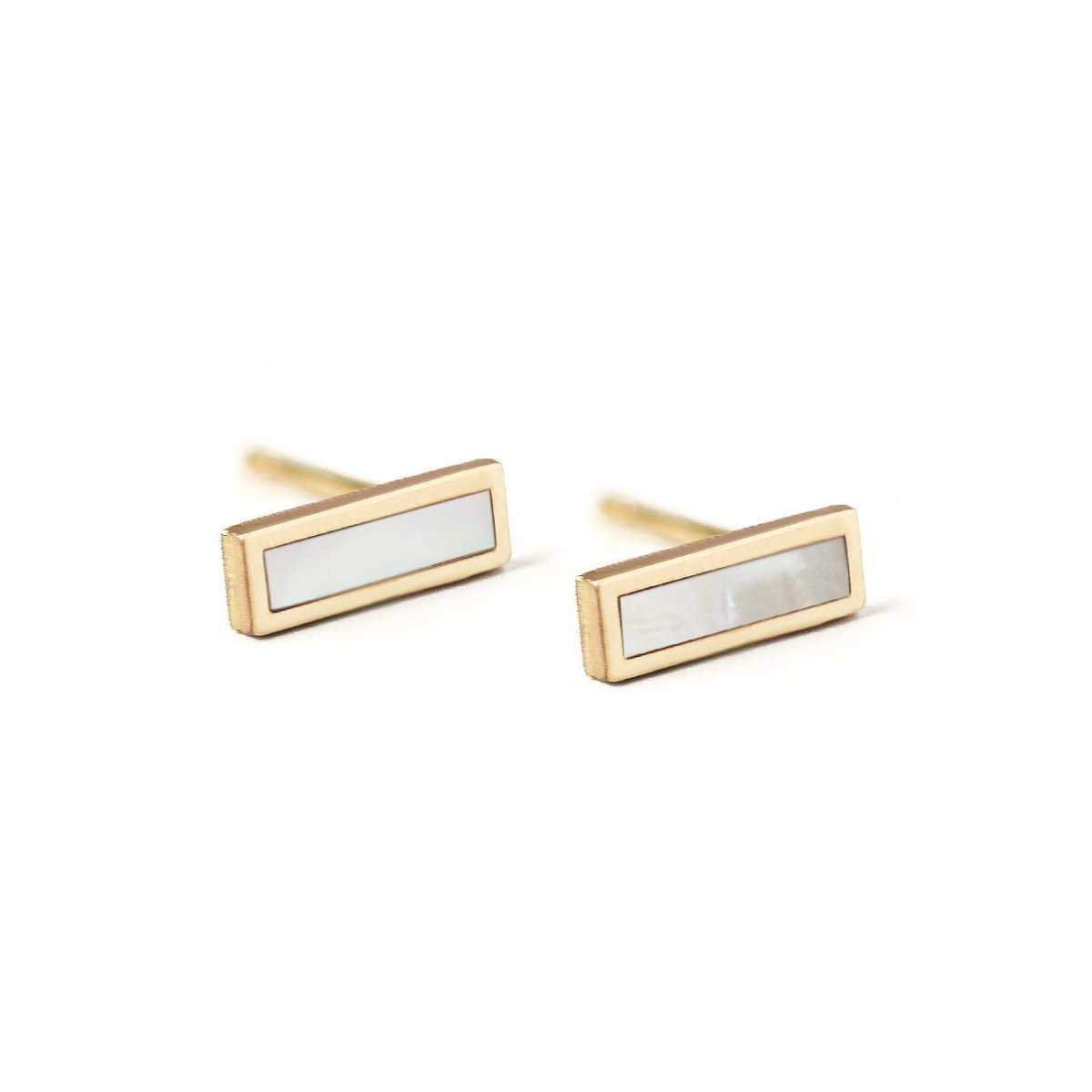 Pair of 14K gold mother of pearl bar studs with pale iridescent stones, on a white background