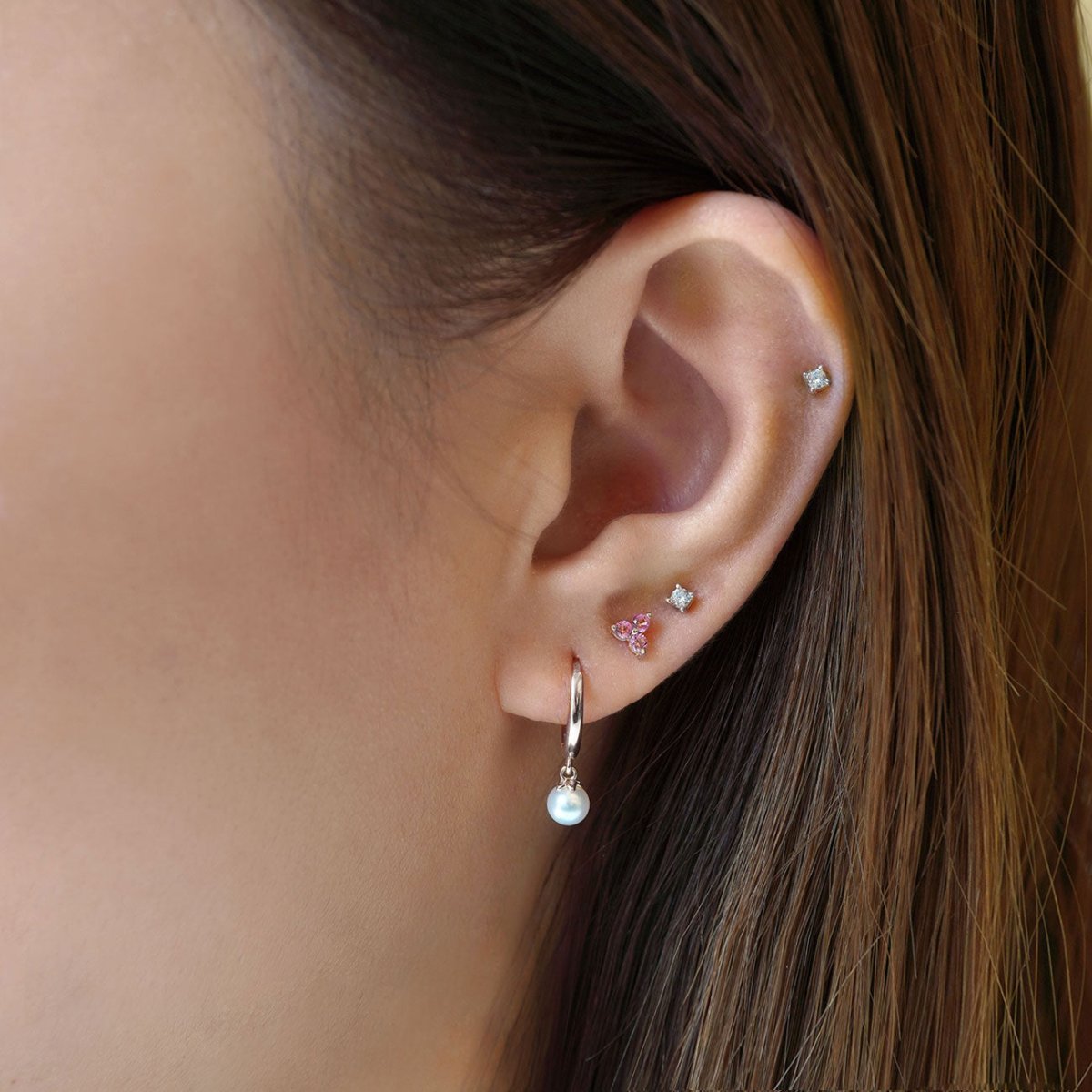 Close up of woman's ear featuring Sterling Silver Birthstone Studs Set Fuchsia Sapphire and opal hoop earring