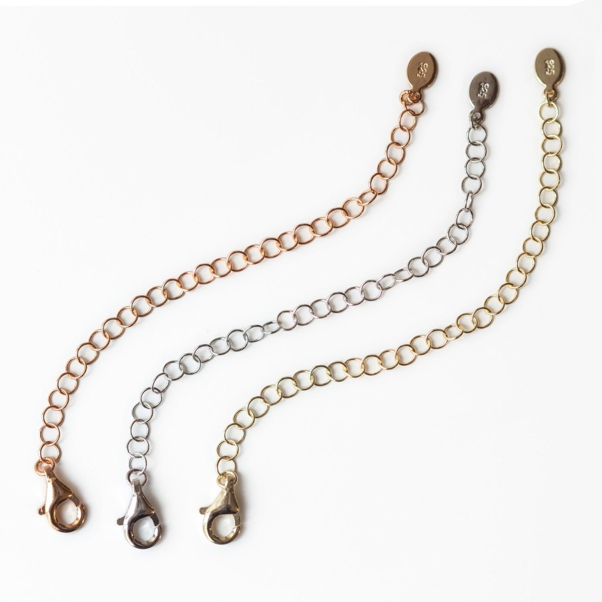 Three choker necklace extender chains in rose gold, silver and gold tones, on a white background