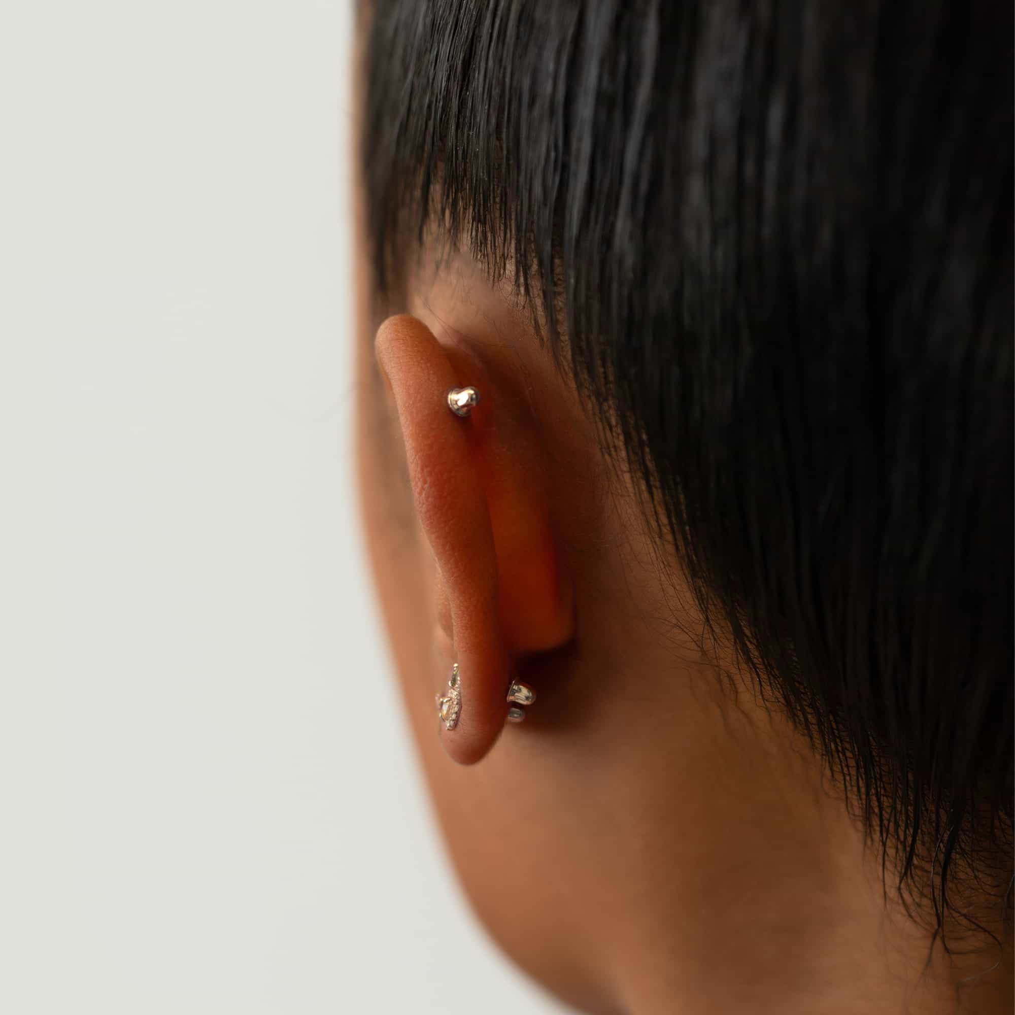 14K white gold screw-back earring backs shown on a model's lobe and helix