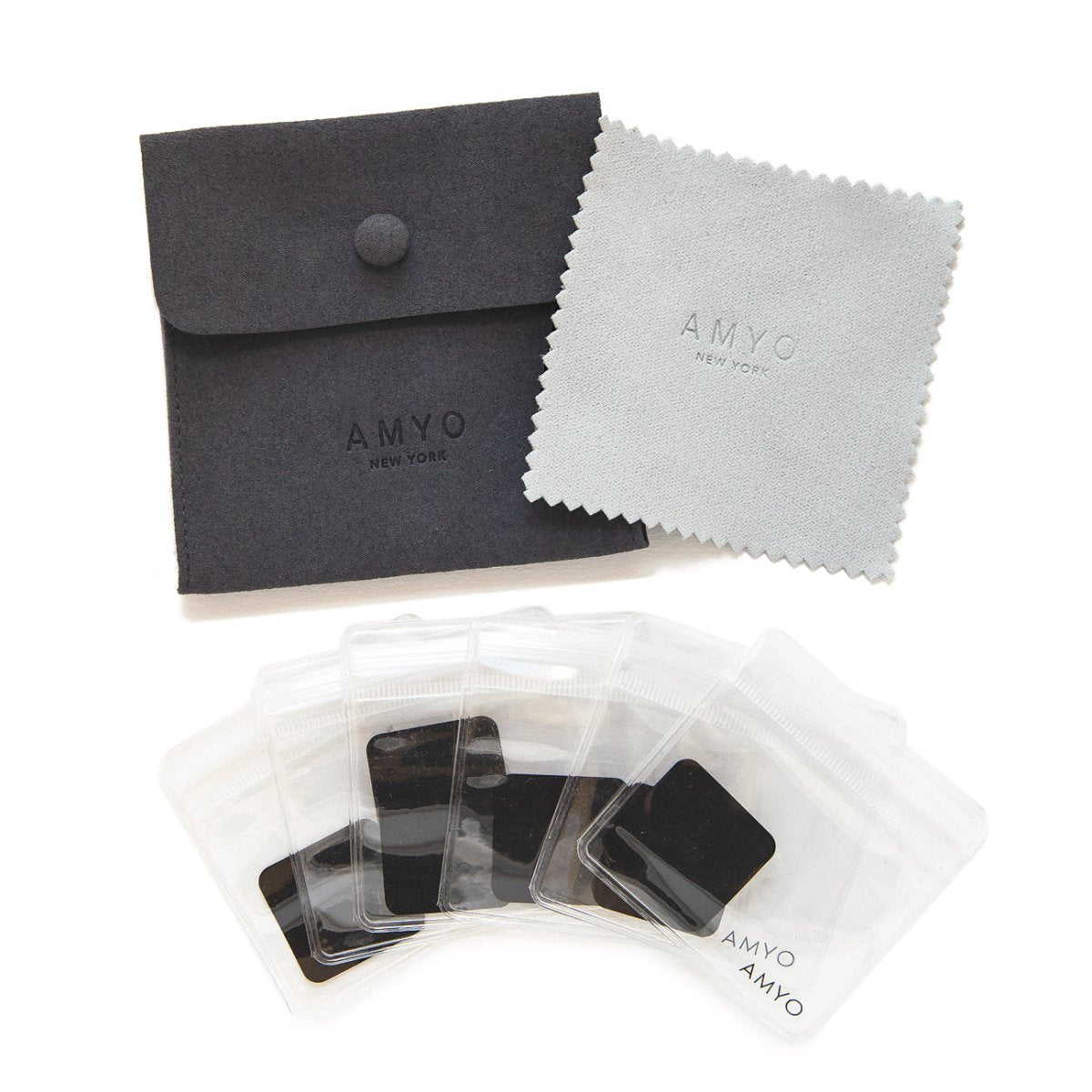 Dark grey AMYO jewelry storage pouch with a polishing cloth and adhesive squares, on a white background