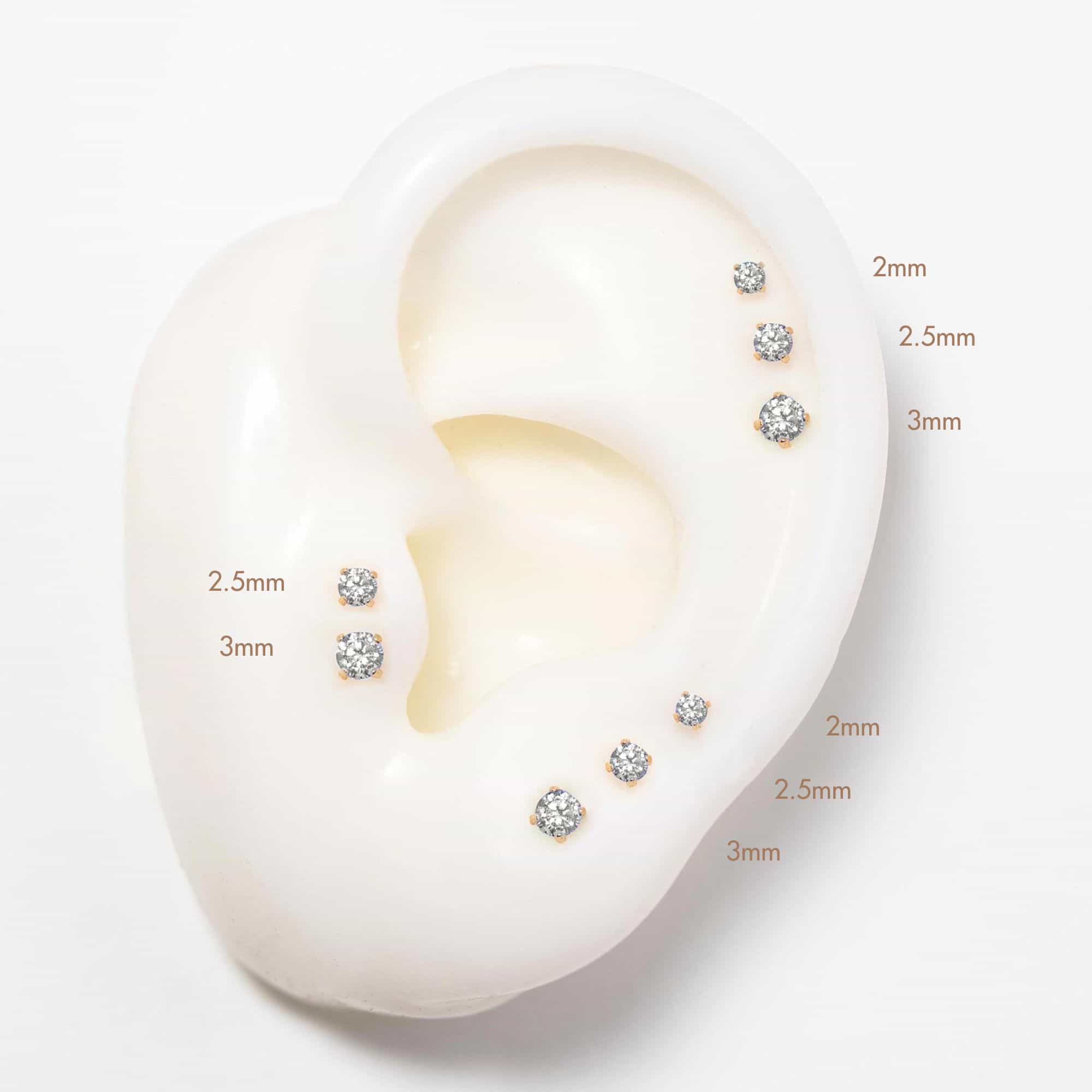 14K white gold flatback studs shown on a model's ear with a curved hoop in the lobe