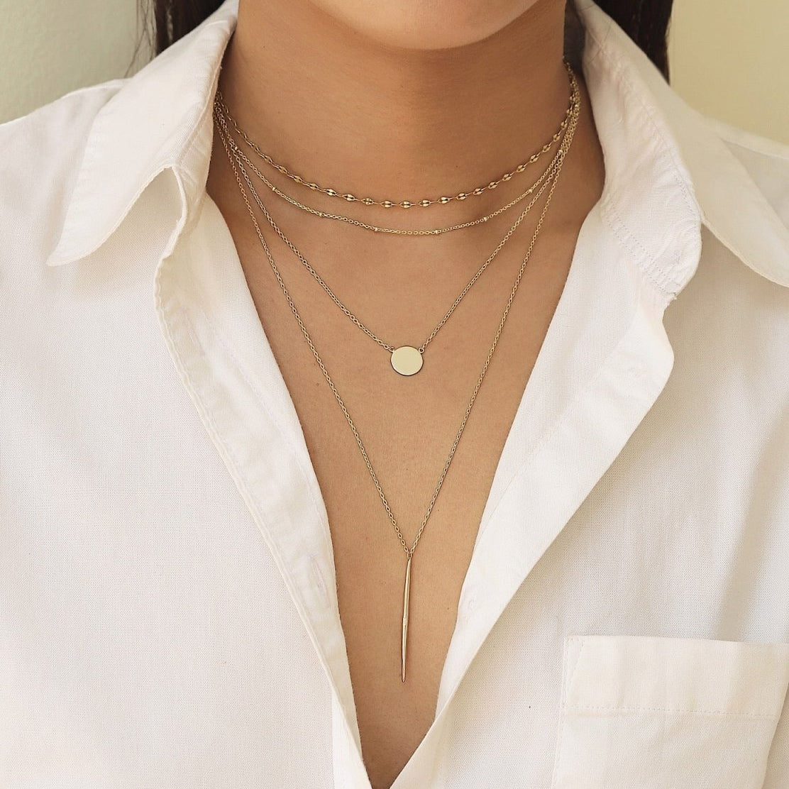 Gold vermeil needle necklace spike bar pendant, close-up detail on a white background