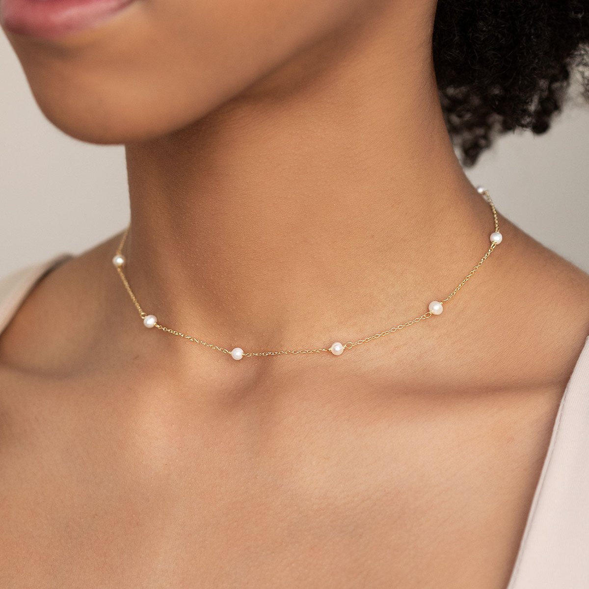 Gold vermeil pearl-station choker necklace shown on a model's neckline