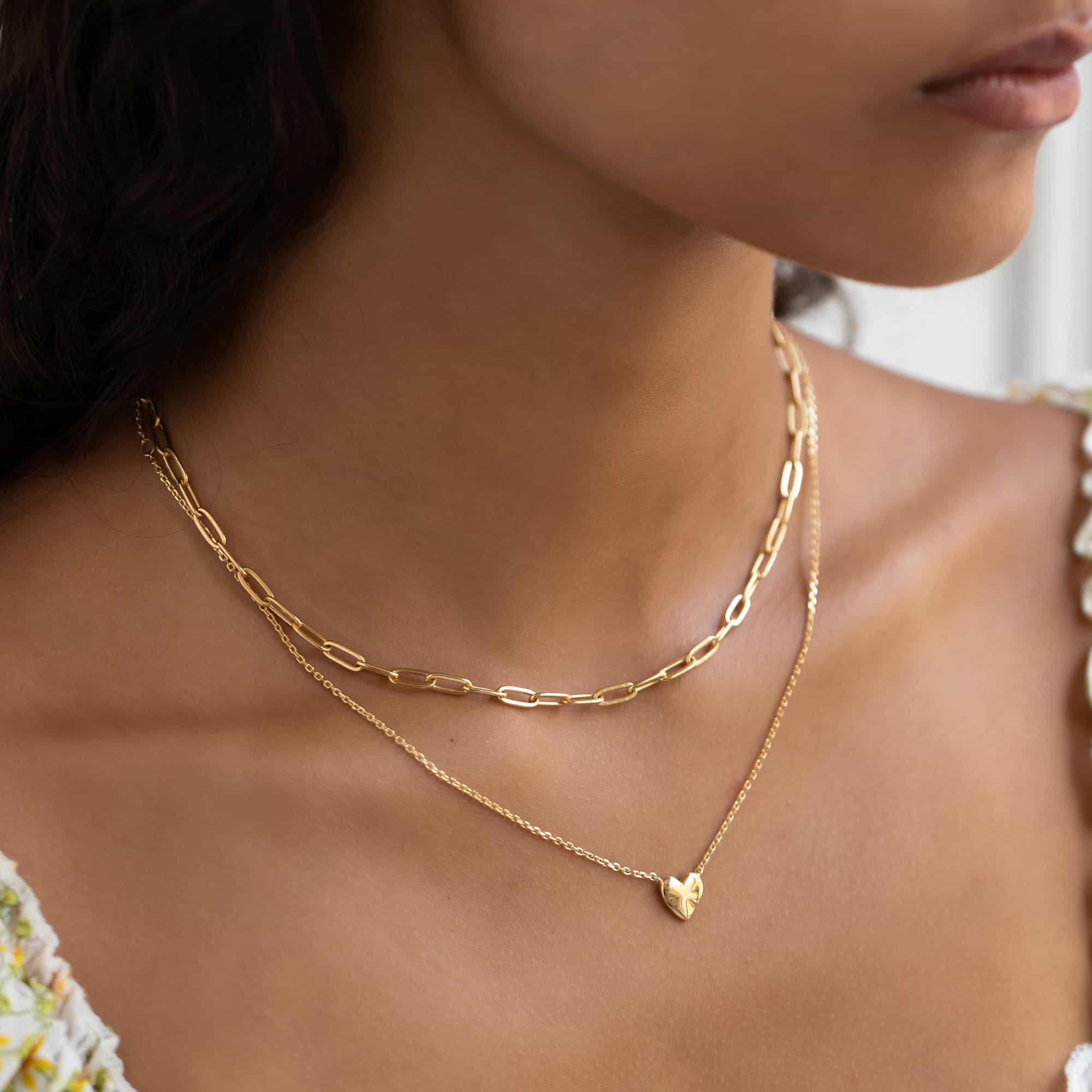 Gold vermeil paperclip chain necklace layered with a finer chain, shown on a model's neckline
