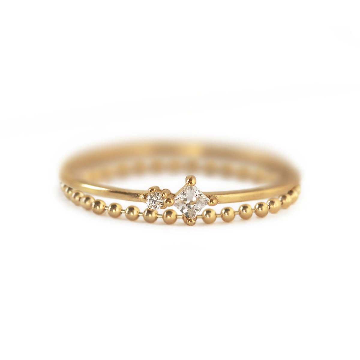 Gold vermeil two-band ring set with white zirconia stones and a beaded band, on a white background