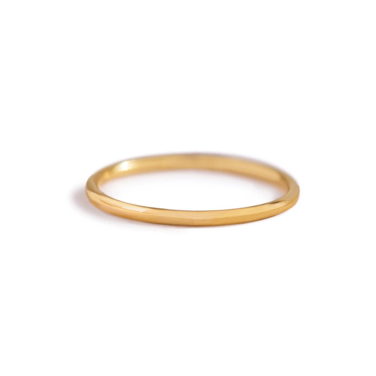 Gold-filled thin stacking ring, a simple smooth round band, on a white background