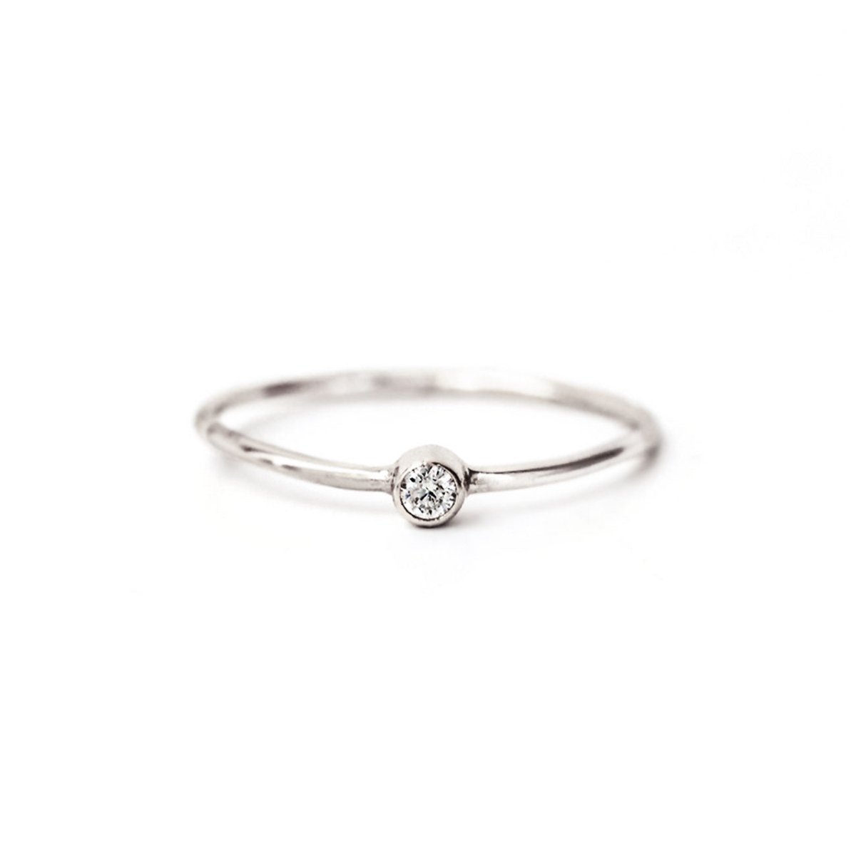 Sterling silver thin solitaire ring with a bezel-set round white zirconia, on a white background