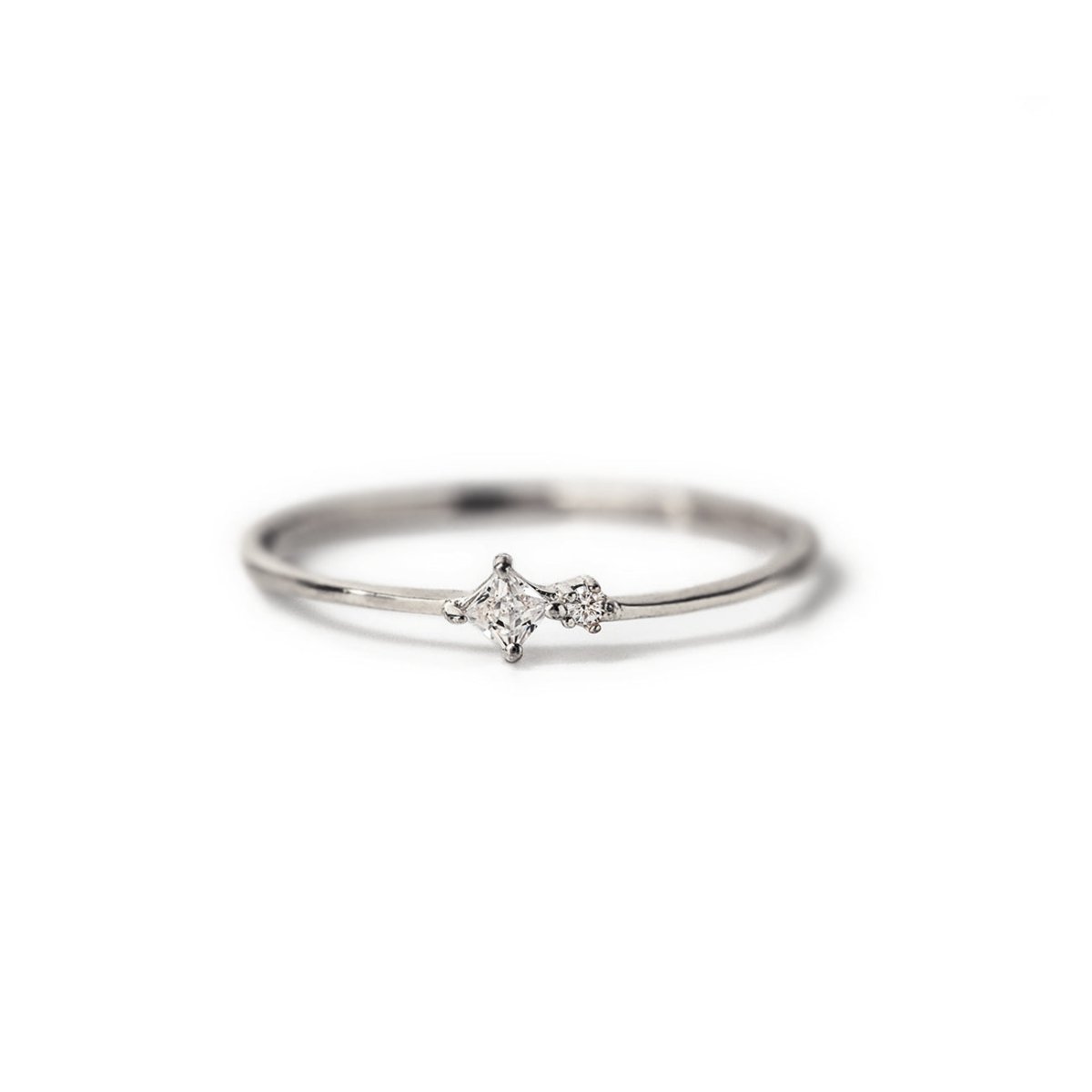 Sterling silver tiny duo ring with a clear zirconia and a small round stone, on a white background