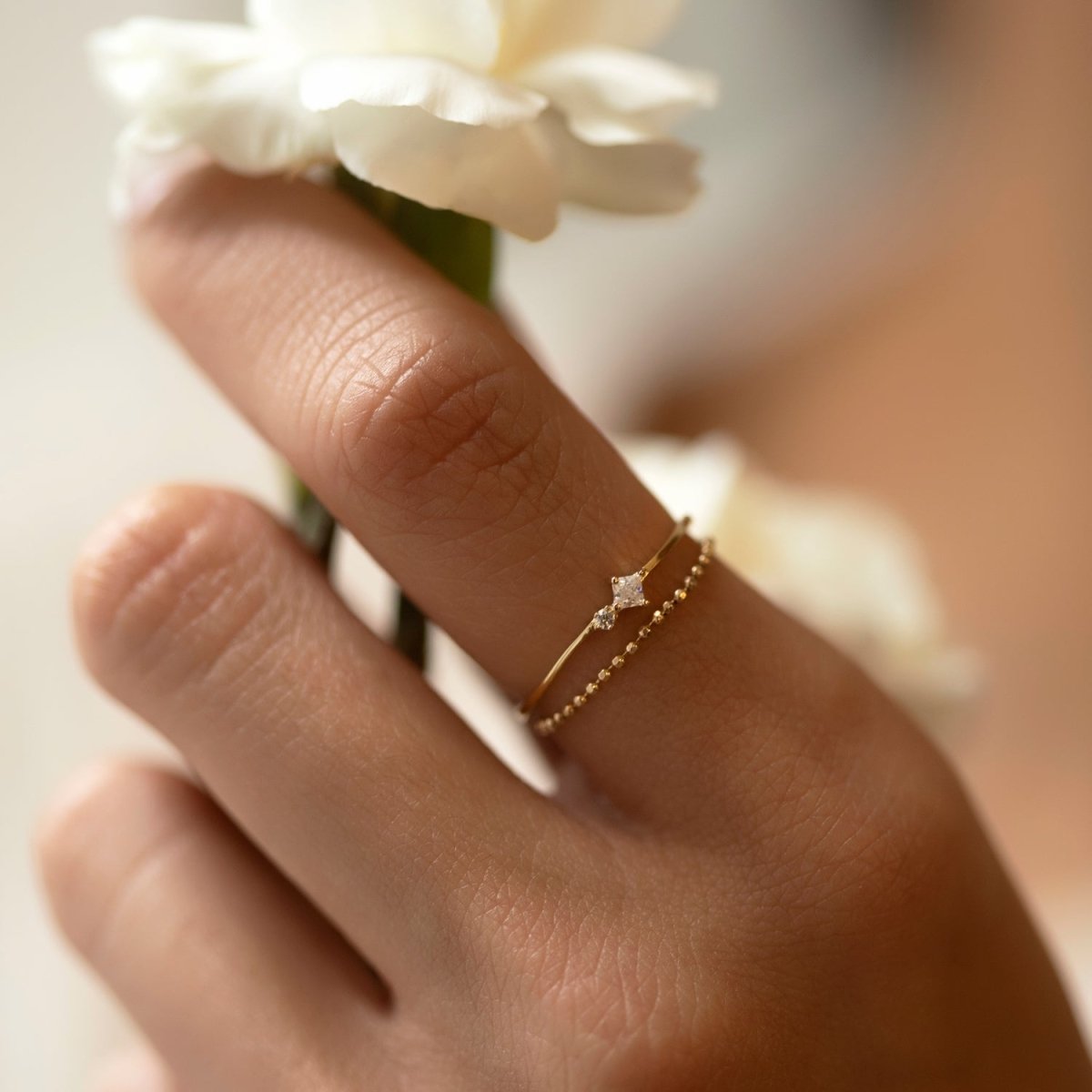 Gold vermeil tiny duo ring stacked with a beaded band, shown on a model's finger