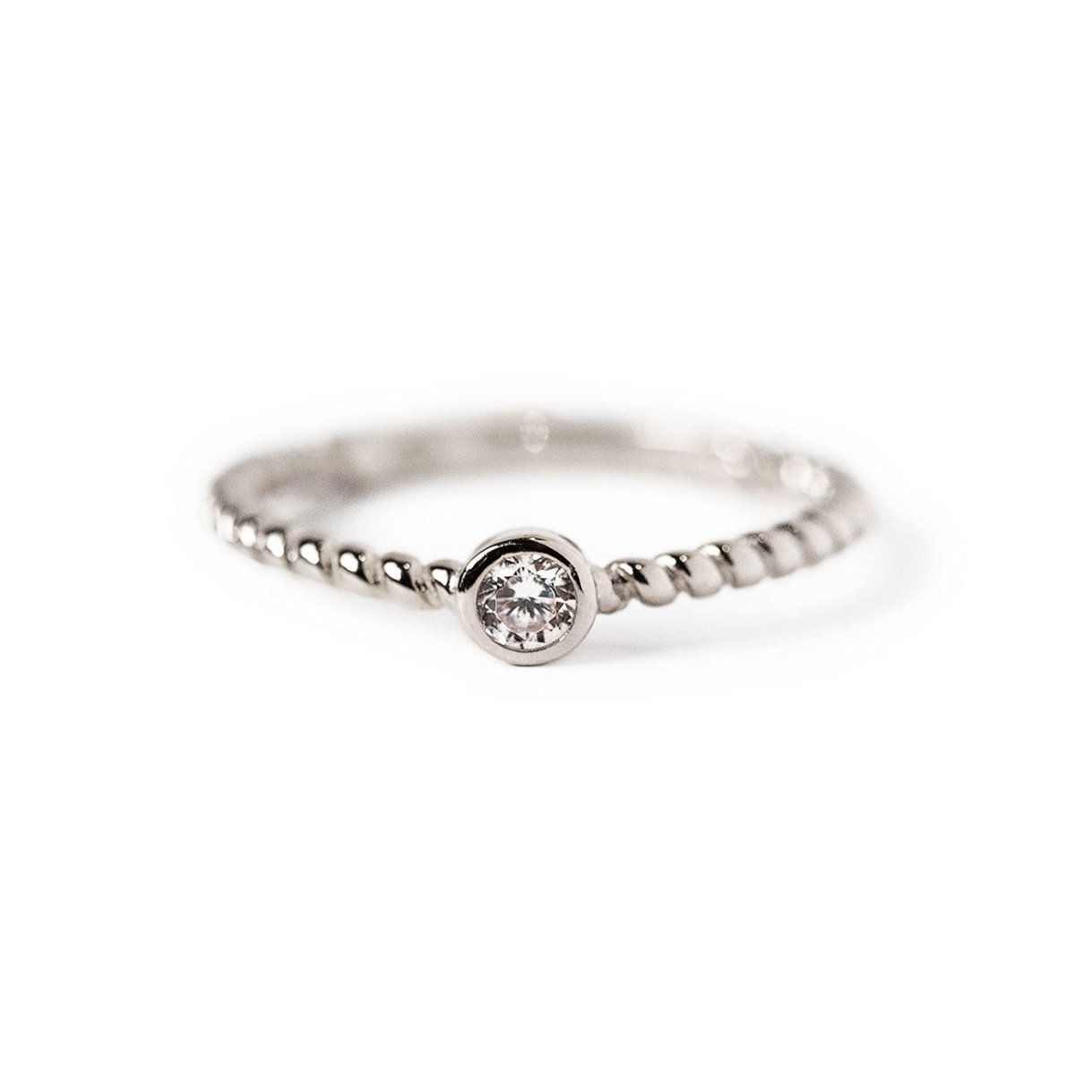 Sterling silver solitaire rope ring with a round clear stone, on a white background