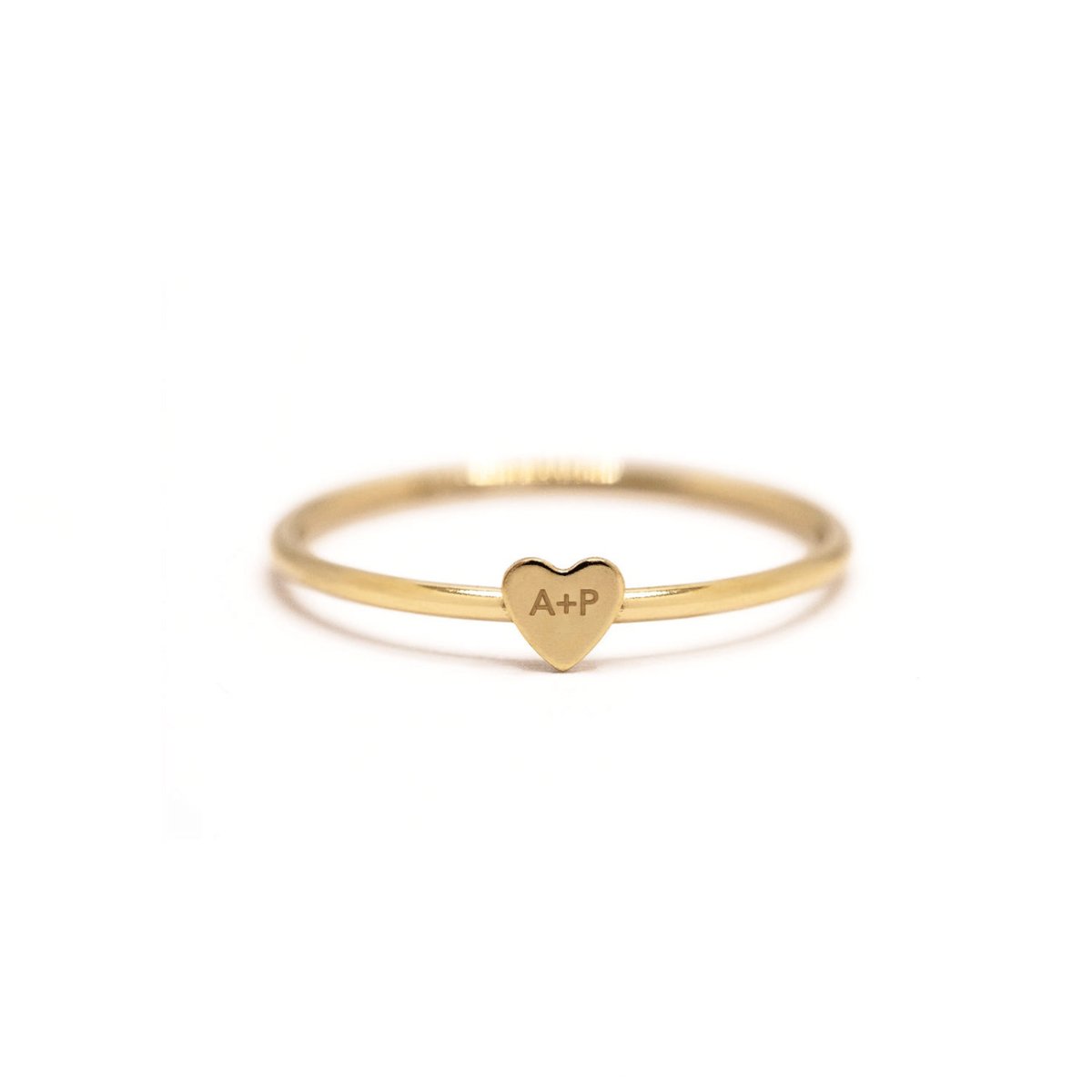 Gold-filled thin band ring with a tiny heart engraved with initials, on a white background