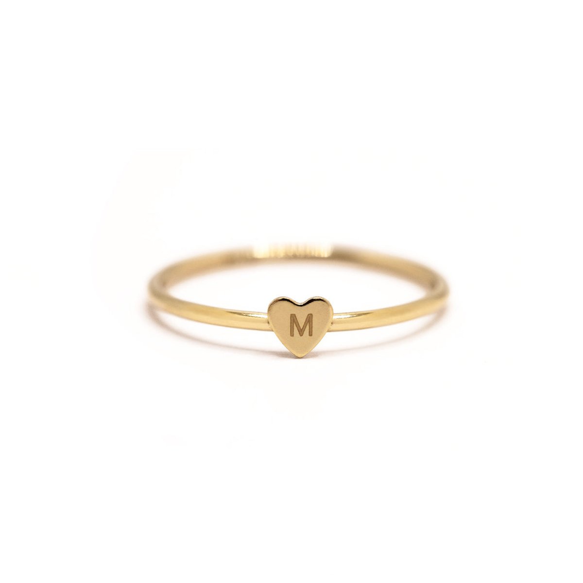 Gold-filled thin band ring with a tiny heart engraved with an initial, on a white background