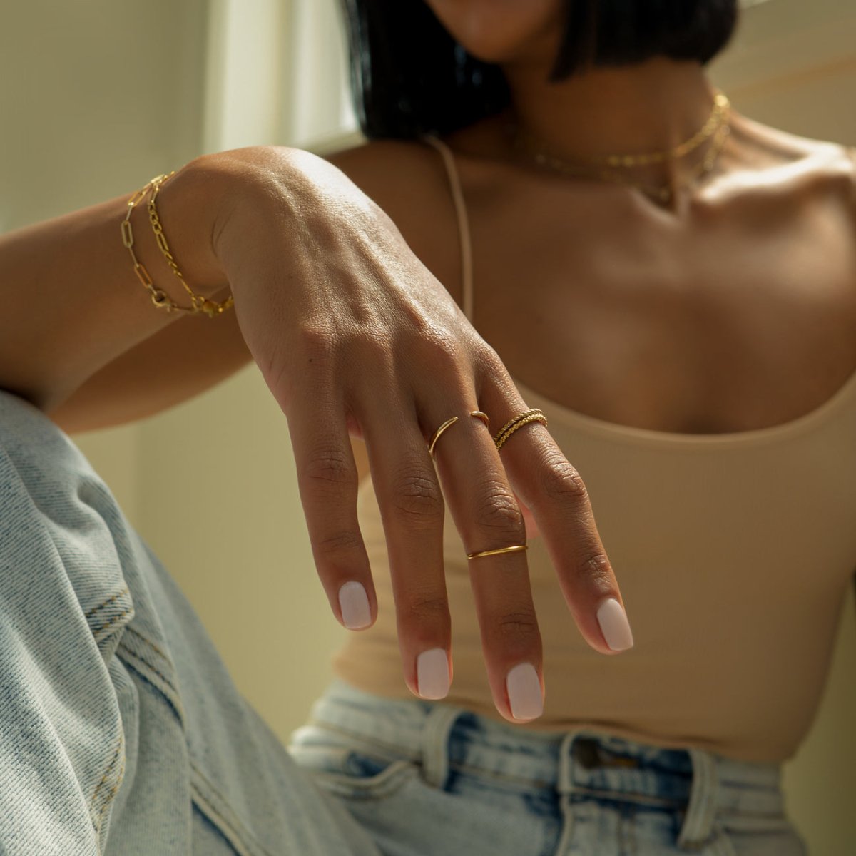 Gold vermeil eternity bead ring stacked with thin rings, shown on a model's hand