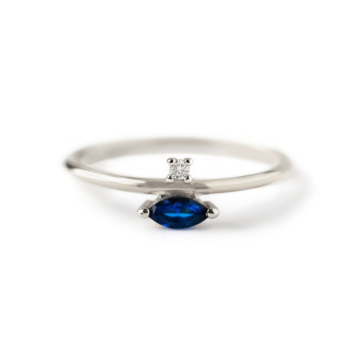 Sterling silver ring with a blue sapphire marquise stone and a small clear accent stone, on a white background