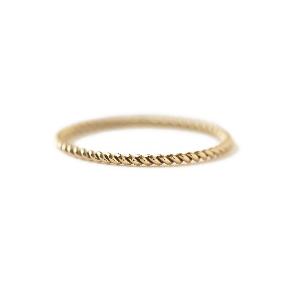 Gold-filled thin twisted rope ring on a white background, close-up detail