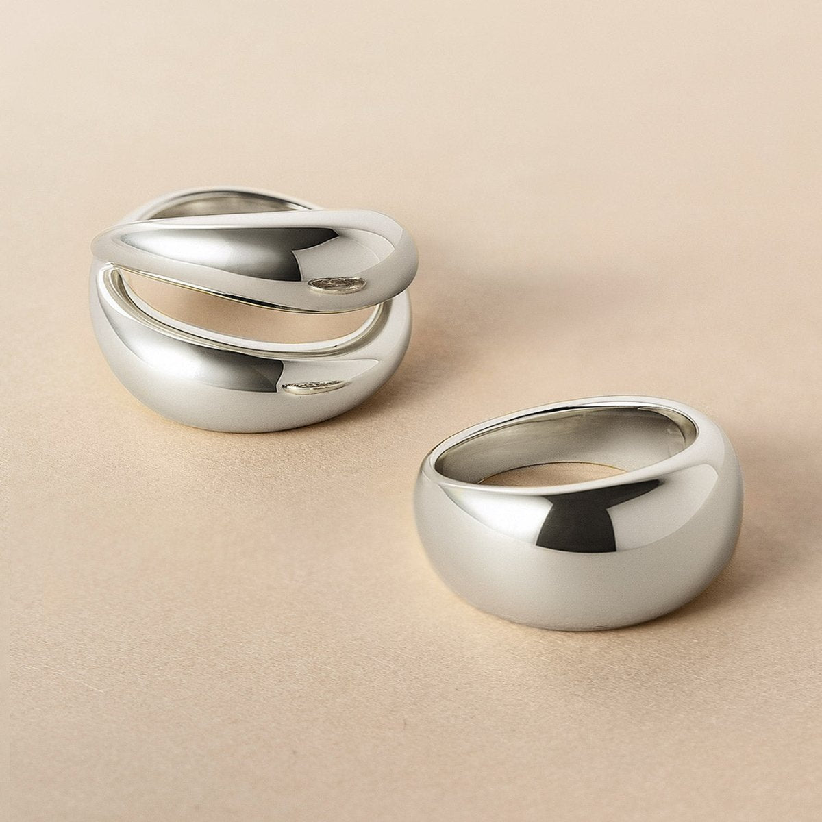 Sterling silver domed ring beside a double-band domed ring, on a cream background