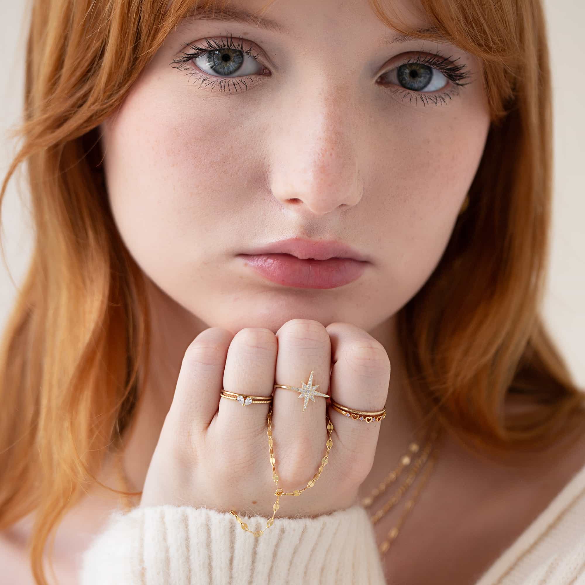 Gold vermeil twin pear white zirconia ring shown on a model's finger among stacked rings