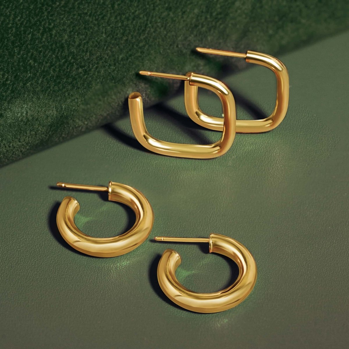 AMYO Gold hoop earrings on a green surface
