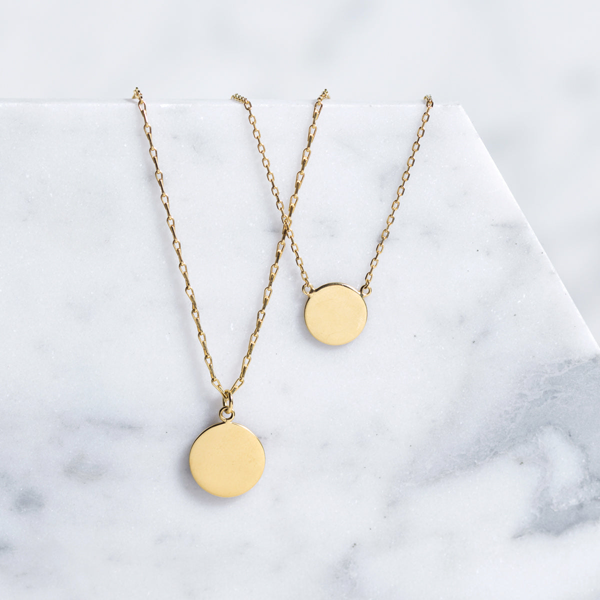Gold vermeil layered necklace duo with two round discs, shown on a model's neckline