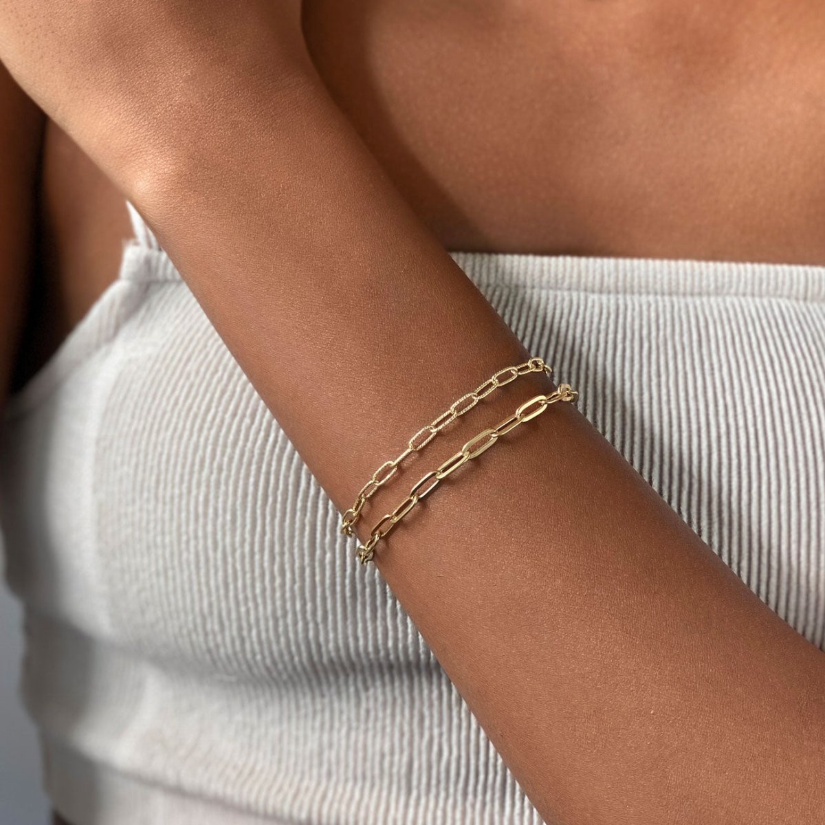 Gold vermeil oval link chain bracelet stacked with a second chain, shown on a model's wrist