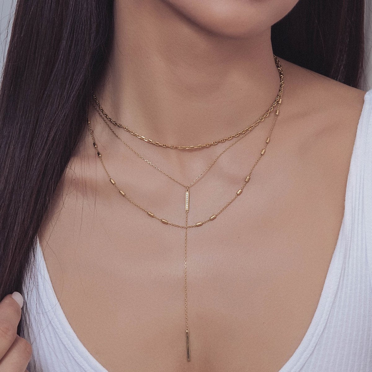 Gold vermeil three-layer lariat necklace with a pavé bar drop shown on a model's neckline