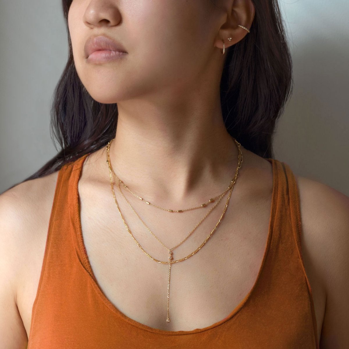 Gold vermeil layered necklace with a fine lariat Y-drop, shown close on a model's neckline