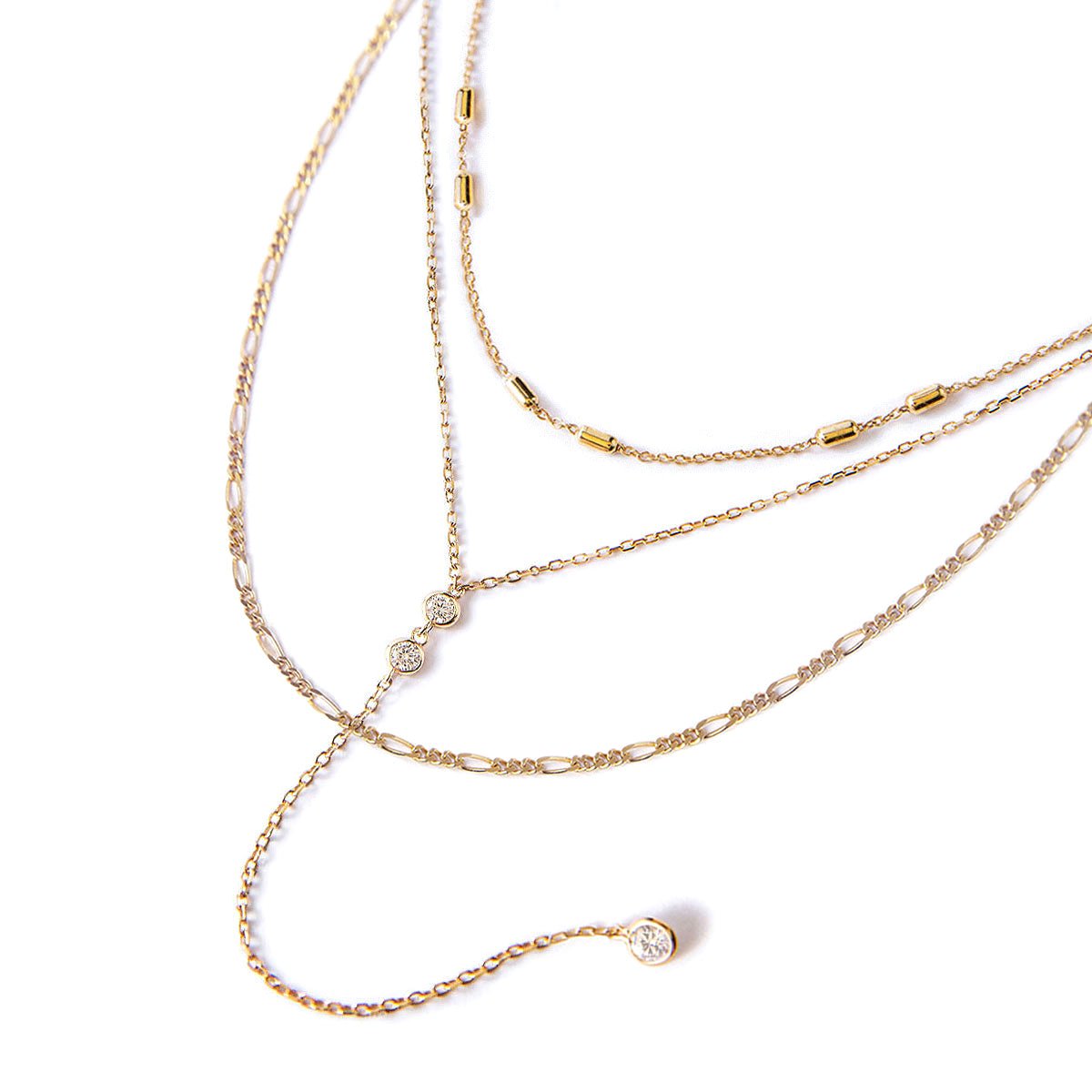 Gold vermeil three-strand layered necklace with bezel-set clear stones, laid flat on a white background