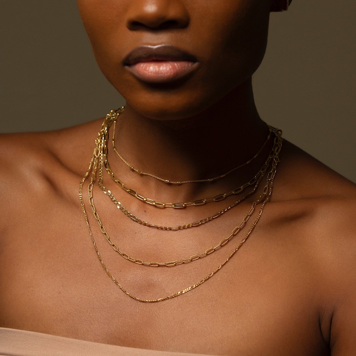 Gold vermeil oval link chain necklace with textured links, laid in an S-curve on a white background