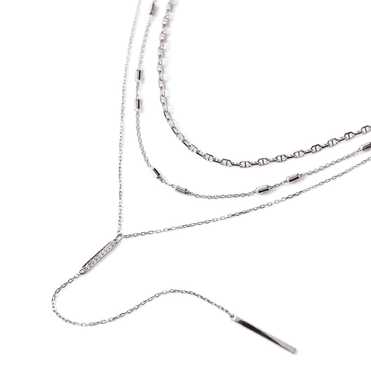 Sterling silver three-layer lariat necklace set with a pavé bar, laid on a white background