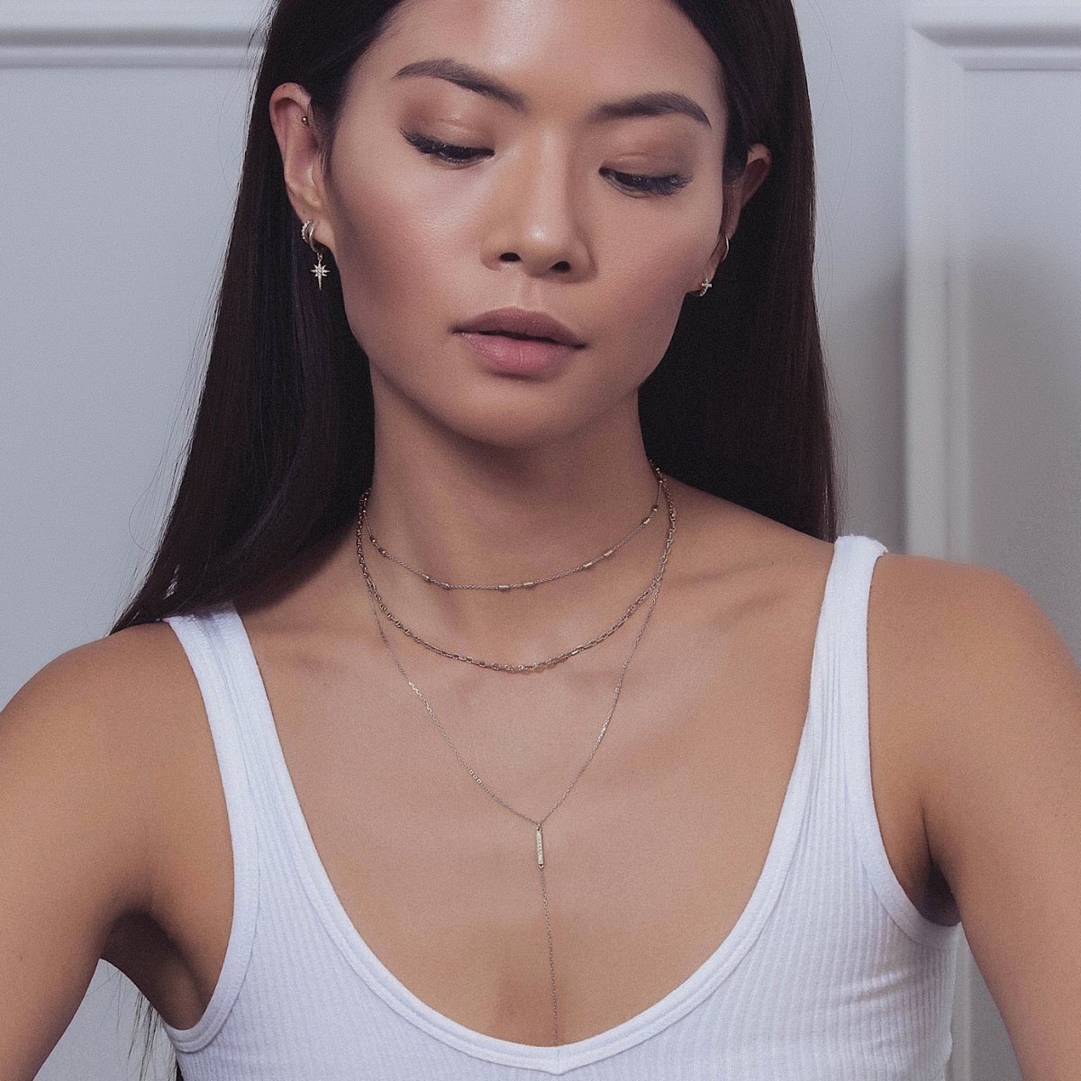 Sterling silver layered chain choker with a disc pendant, shown on a model layered with chains