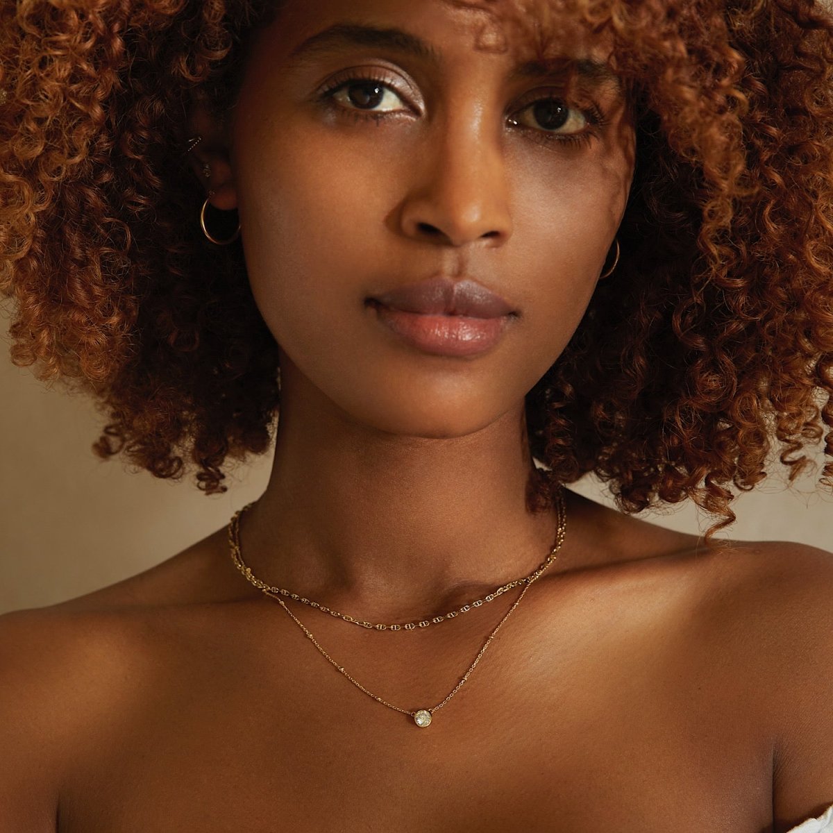 Gold vermeil layered choker with a beaded chain and a single round clear stone, shown on a model's neckline