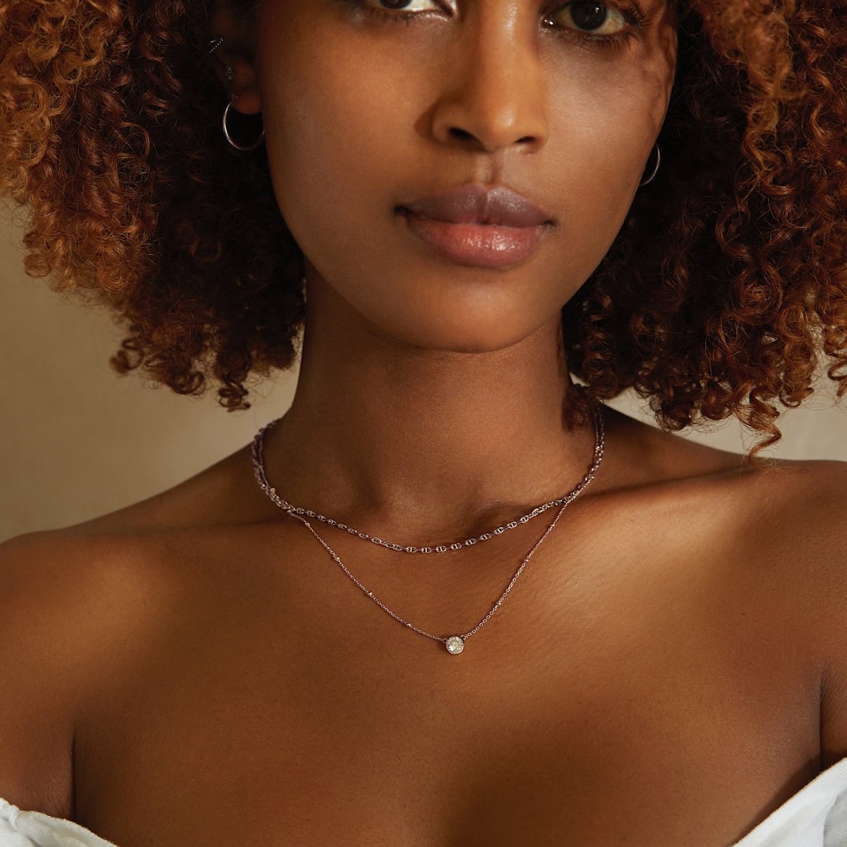 Sterling silver layered choker with a single round clear stone pendant, shown on a model's neckline