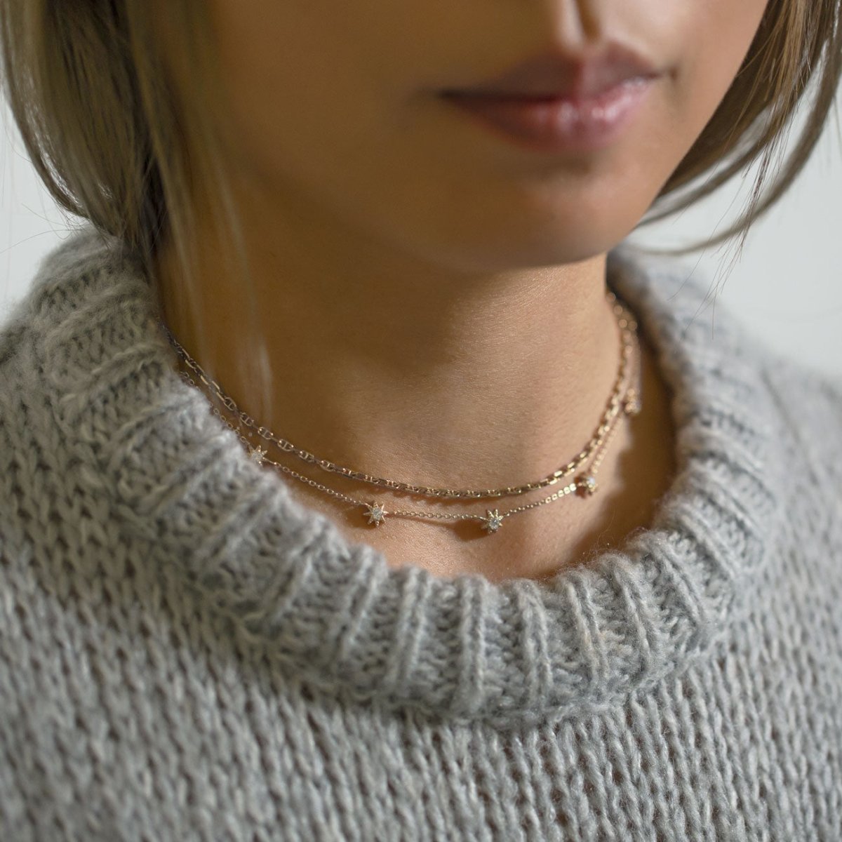 Sterling silver white zirconia starburst necklace doubled at the throat, shown on a model