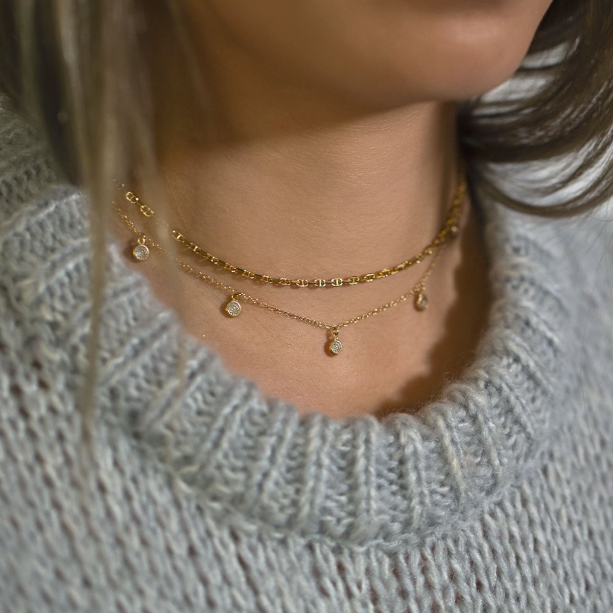 Gold vermeil layered necklace duo with clear crystal drops, shown on a model over a gray sweater