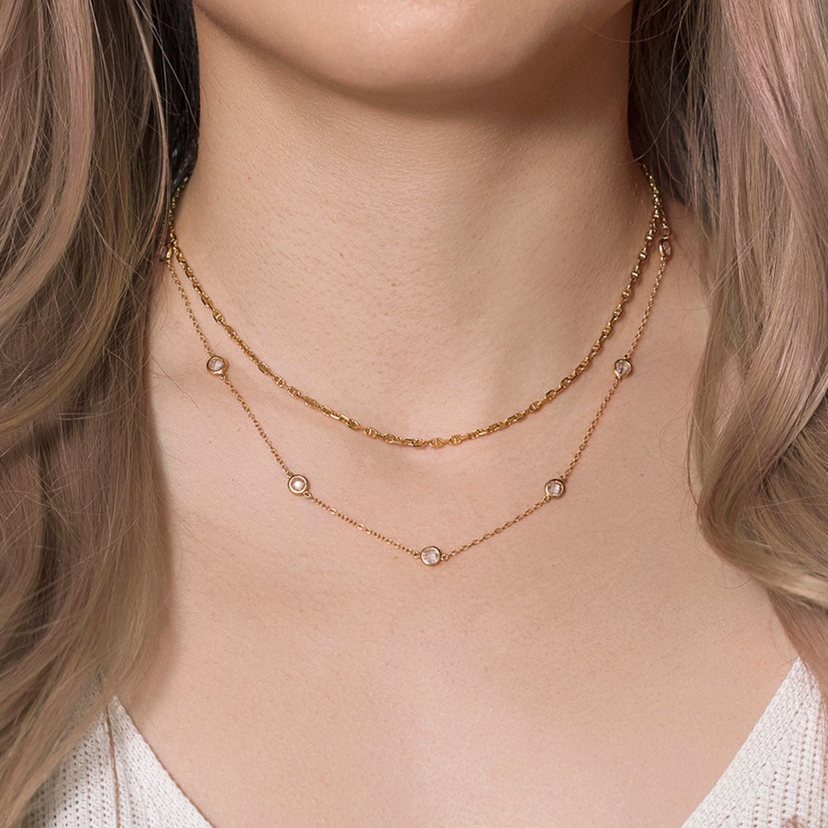 Gold vermeil Marina chain layered with a clear crystal station chain, shown on a model's neckline