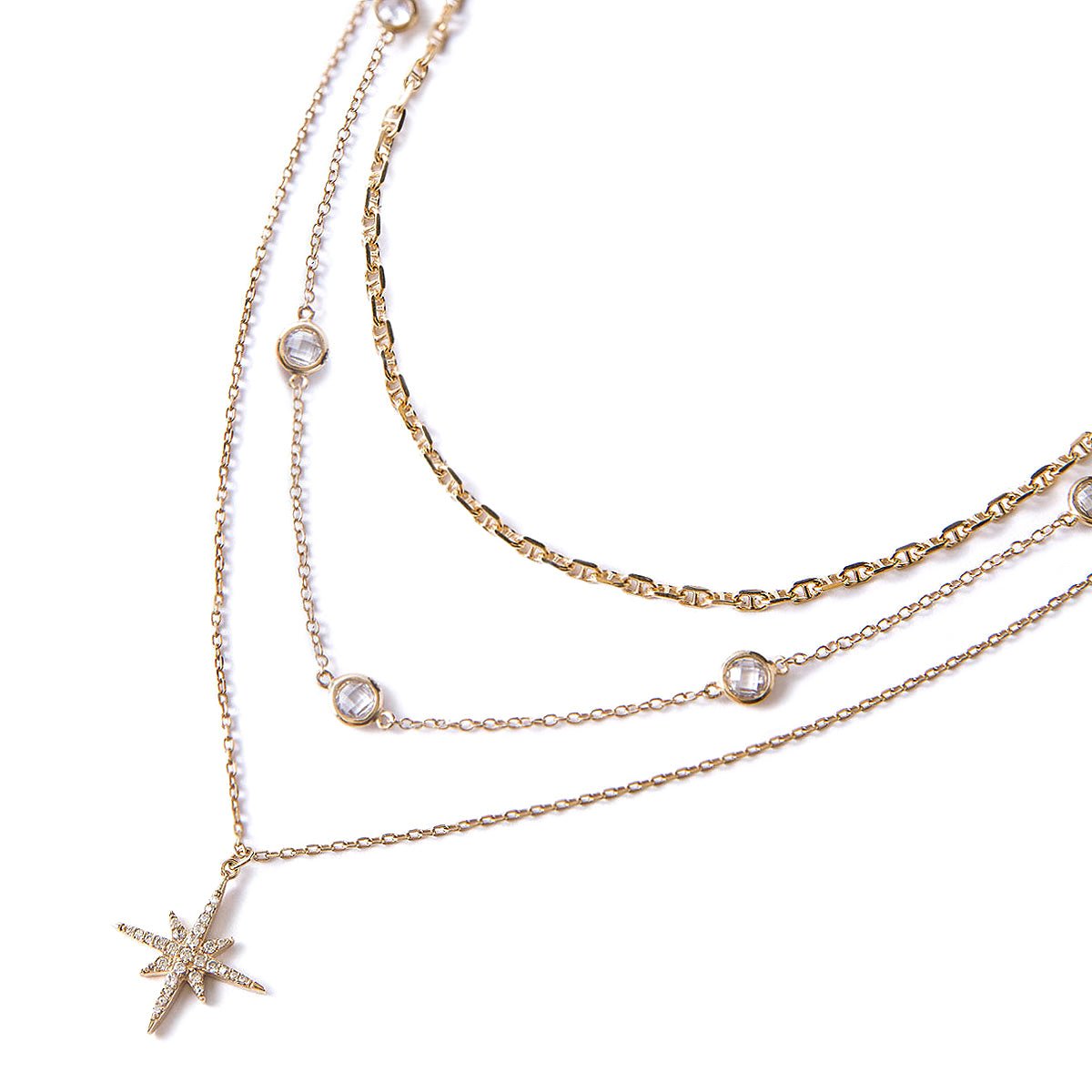 Gold vermeil layered trio with a pavé star pendant, Marina chain and clear stones, on a white background