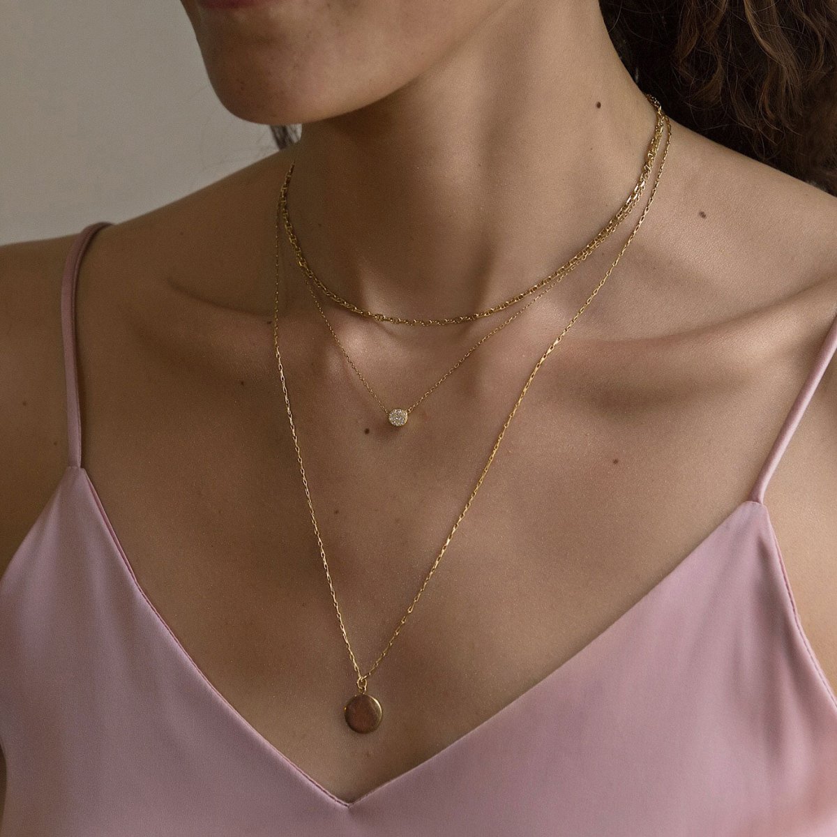 Gold vermeil Marina chain, crystal disc and round disc pendant layered trio, shown on a model's neckline