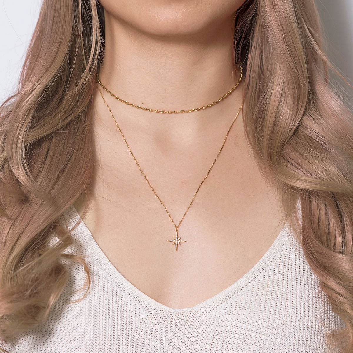 Gold vermeil layered duo with a clear crystal starburst pendant, shown on a model's neckline