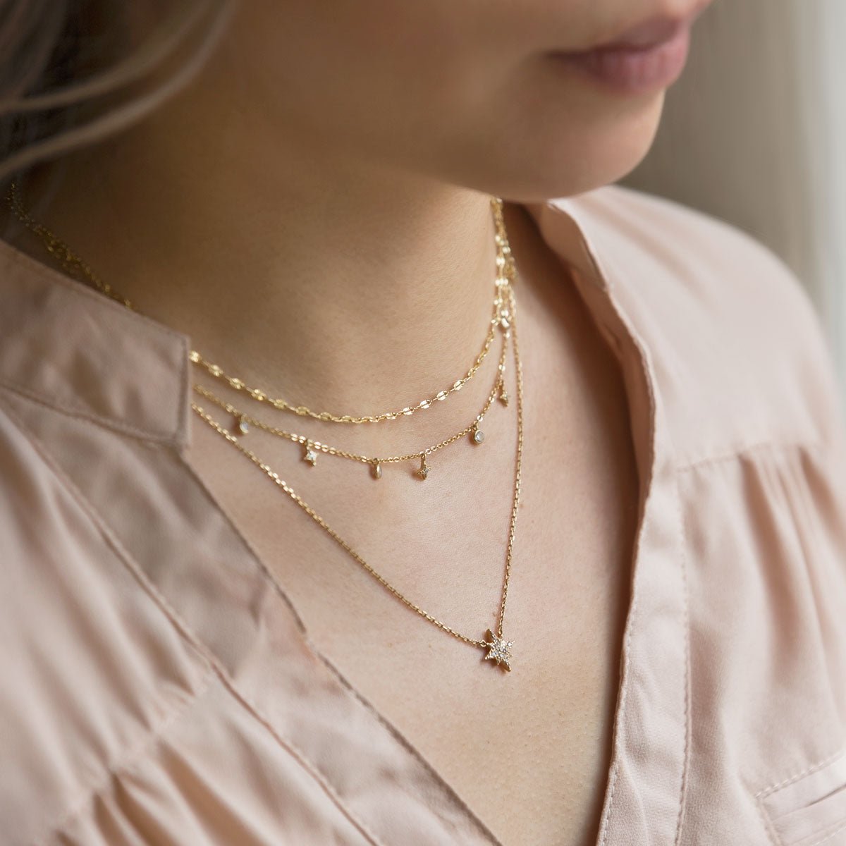 Gold vermeil layered star and zirconia drop chains with a pavé star pendant, shown on a model's neckline