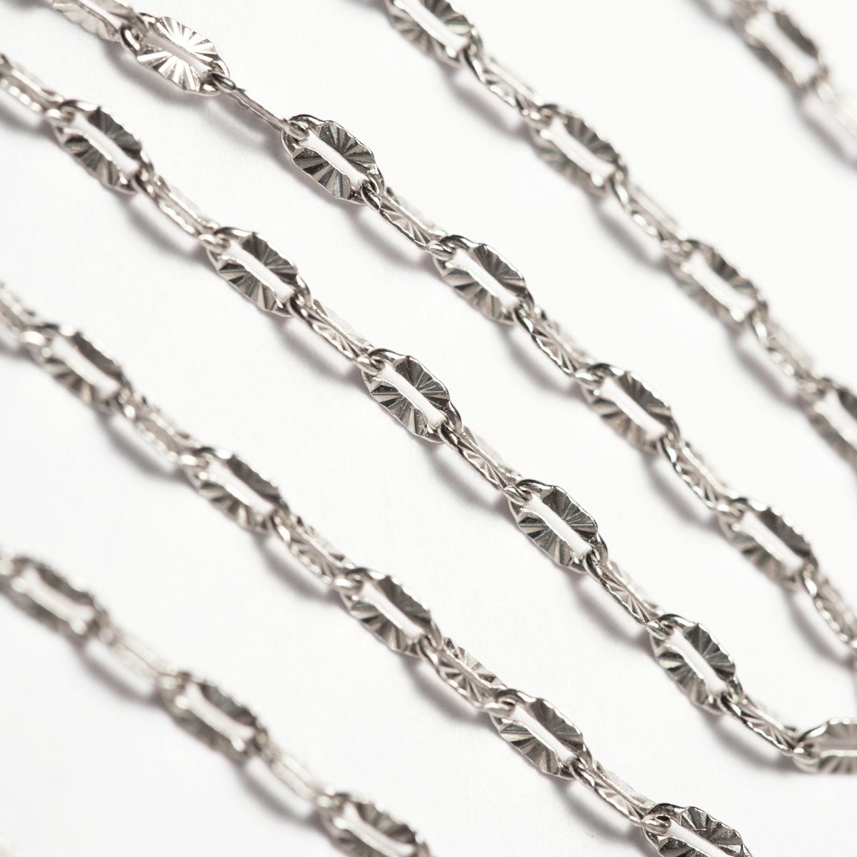 Sterling silver diamond-cut lace chain, close-up detail on a white background