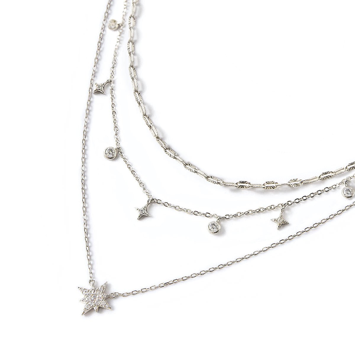 Sterling silver layered trio of star and zirconia drop chains with a pavé star pendant, on a white background