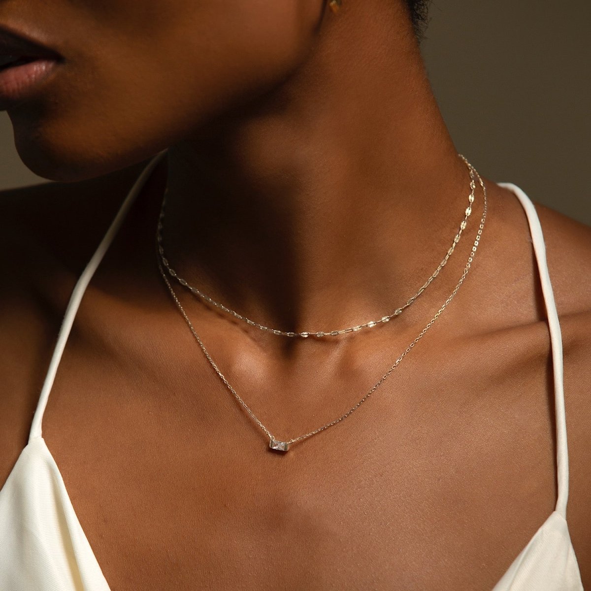 Sterling silver lace chain choker with a small clear stone, shown on a model's neckline