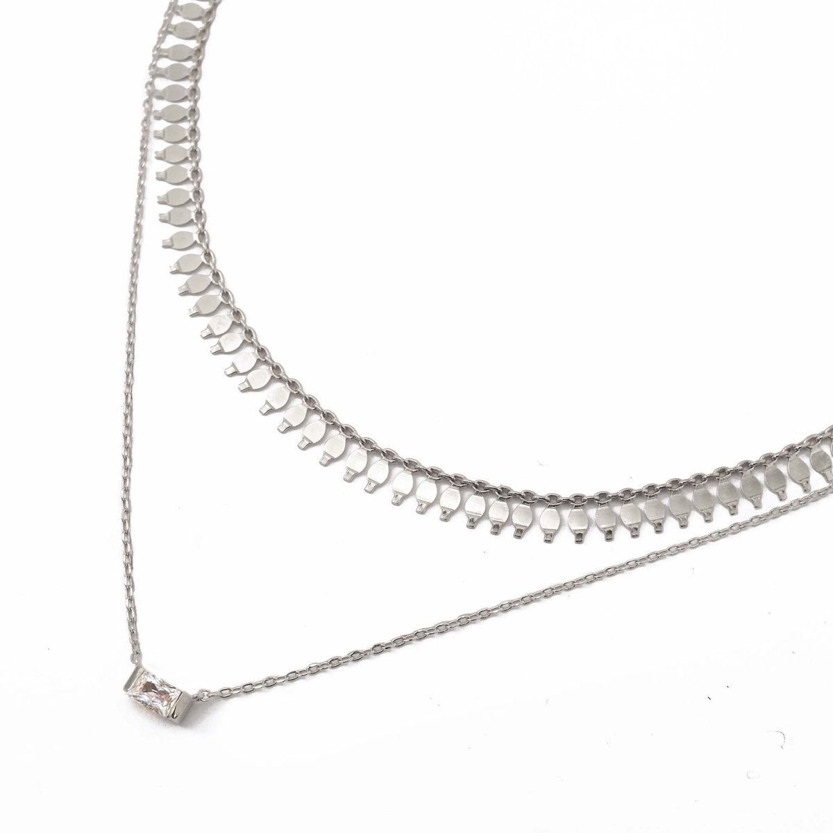 Sterling silver layered duo with a clear baguette stone pendant, on a white background