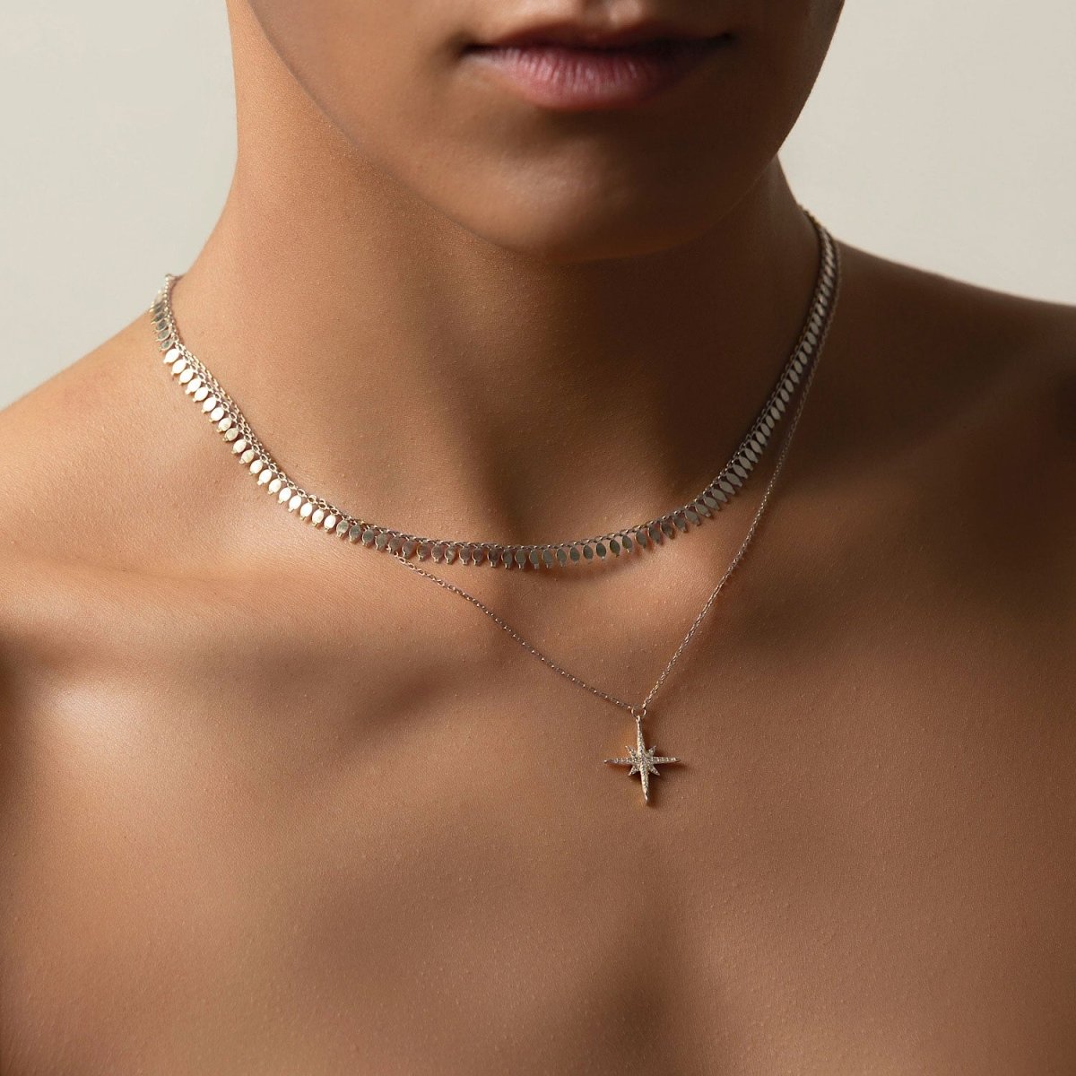 Sterling silver fringe chain choker layered with a fine star pendant chain, shown on a model's neck