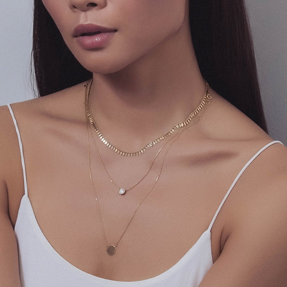 Gold vermeil fringe choker layered with a bezel clear stone and disc coin, shown on a model's neckline