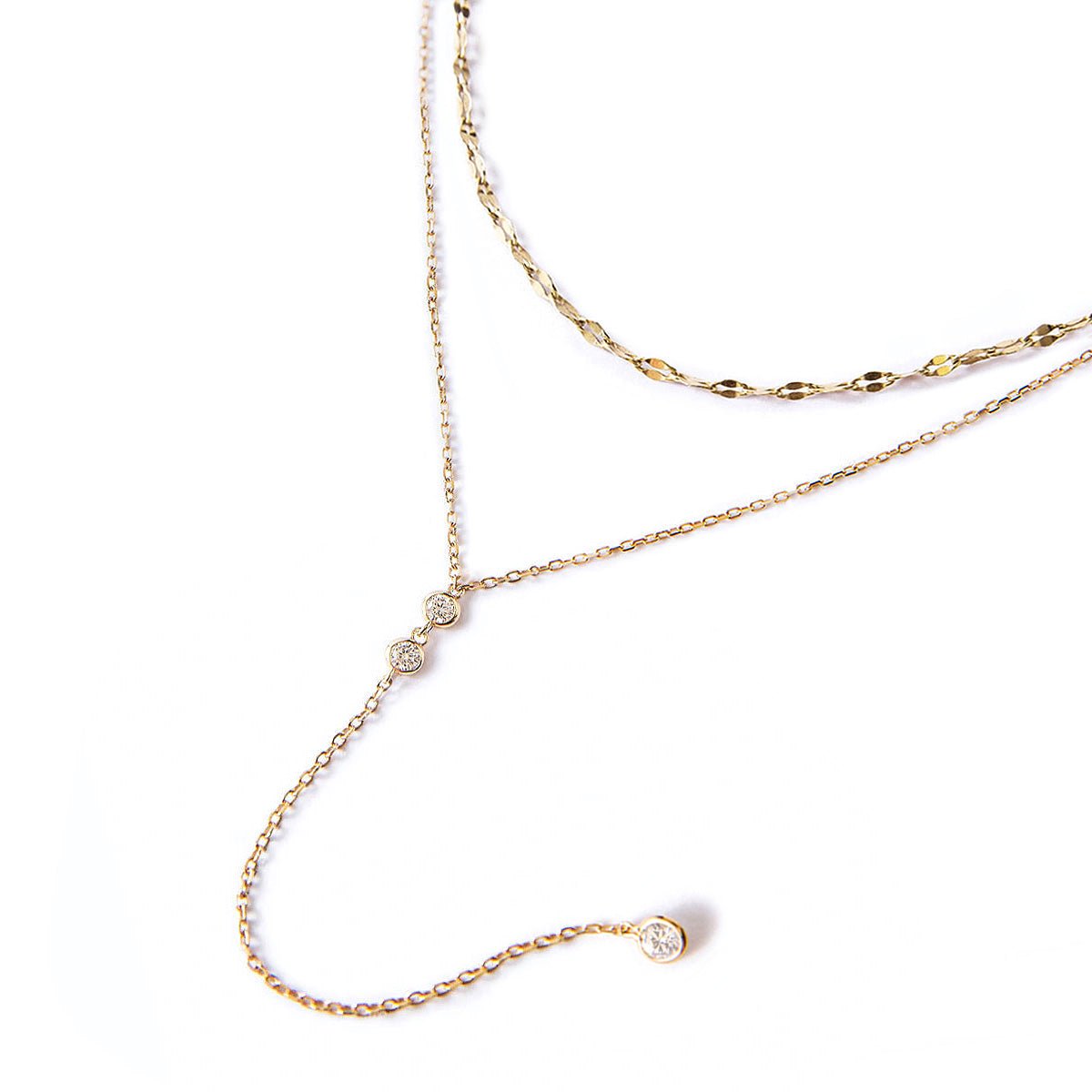 Gold vermeil layered lariat duo with a textured chain and dangling clear stones, on a white background