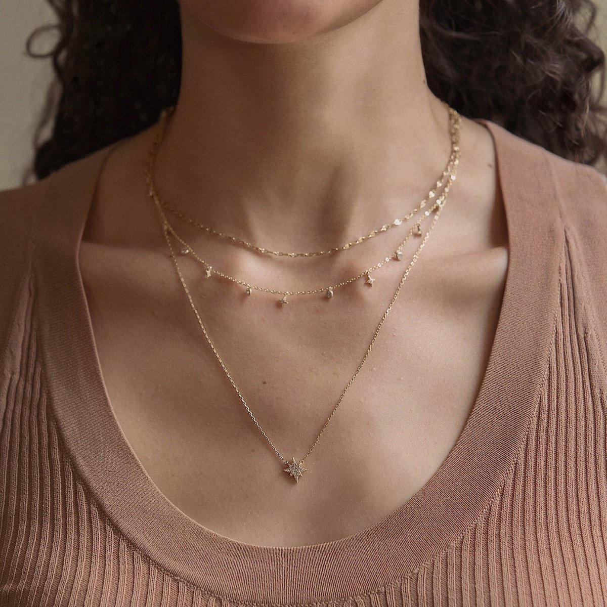 Gold vermeil star and zirconia dangle layered duo shown on a model's neckline