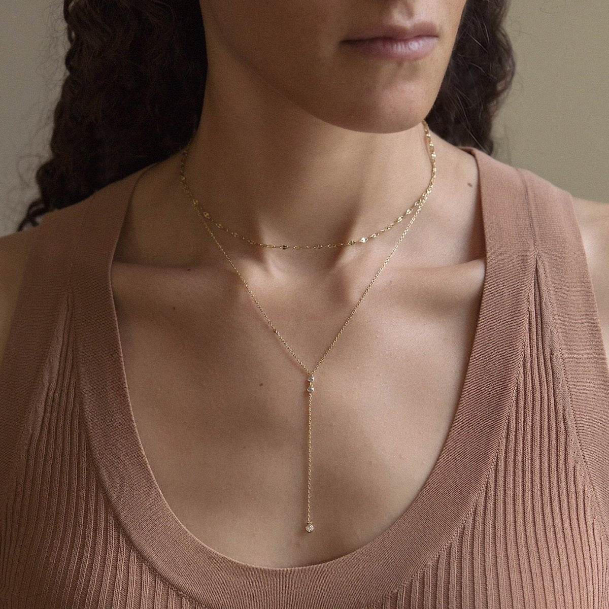 Gold vermeil layered lariat duo with a clear stone Y-drop, shown on a model's neckline