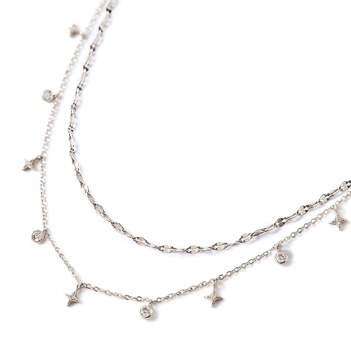 Sterling silver layered necklace duo with dangling star and round clear stone charms, on a white background